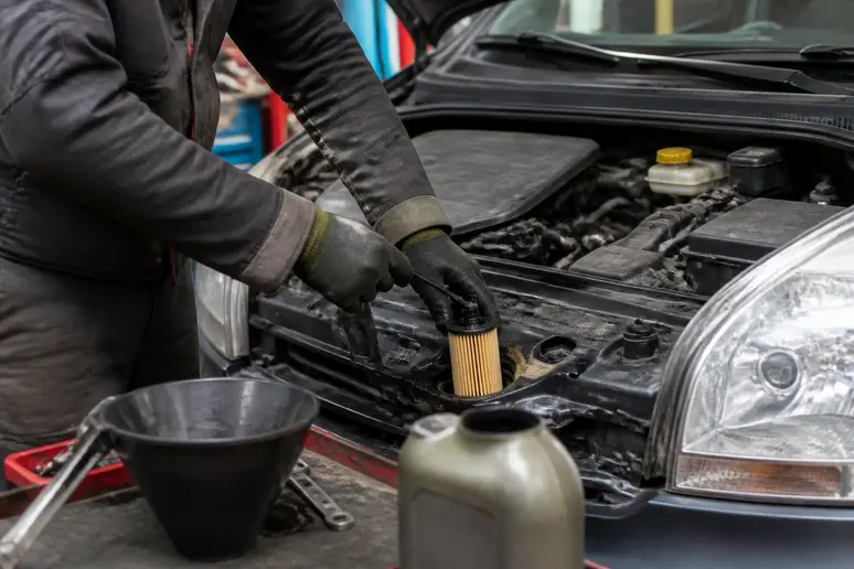 Mécanicien français vérifiant le niveau d'huile lors de l'entretien d'une auto-agila-opel.