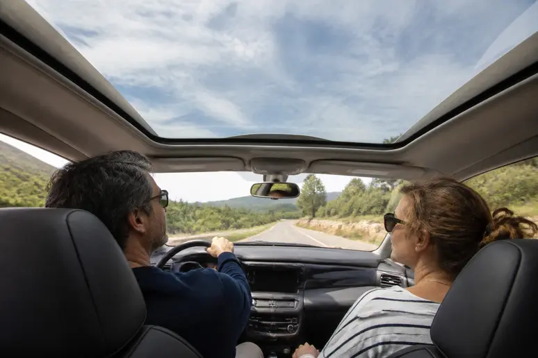 Couple profitant d'une balade pittoresque en Renault Avantime sur une route de campagne française, typique de l'expérience avantime-car.