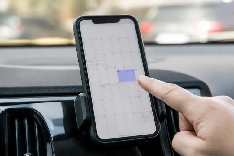 Rappel de contrôle technique périmé 1 mois sur un smartphone dans une voiture.
