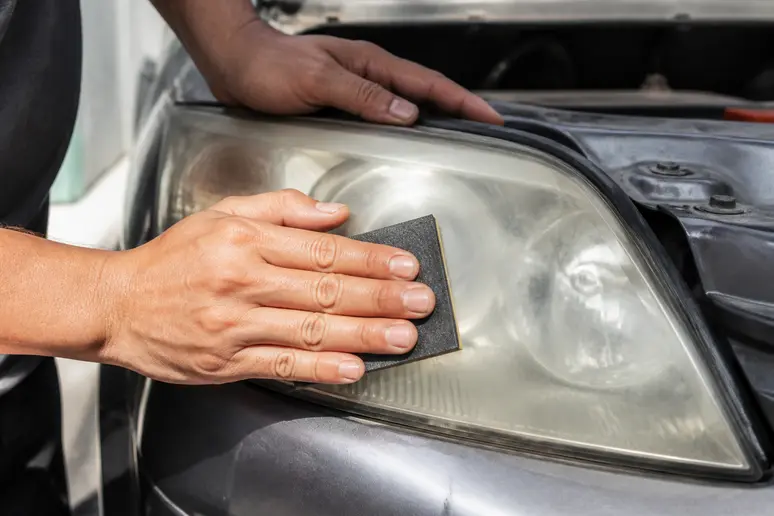 Ponçage manuel d'un optique avec un kit renovation phare sans perceuse dans un garage