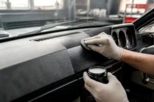 Application minutieuse d un renovateur plastique voiture sur le tableau de bord d une ancienne.