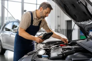 Un mécanicien connecte une valise topdon au moteur d'une voiture dans un atelier lumineux