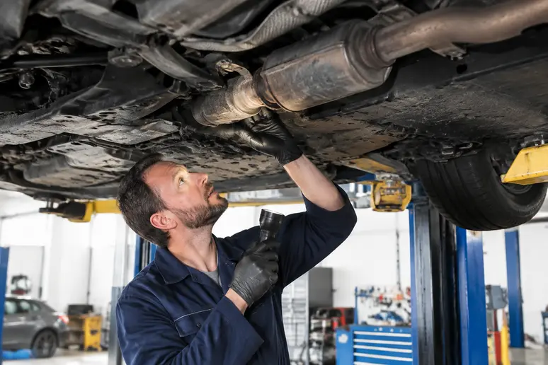 Examen sous un véhicule sur pont élévateur pour vérifier l'état du catalyseur et de la ligne d'échappement